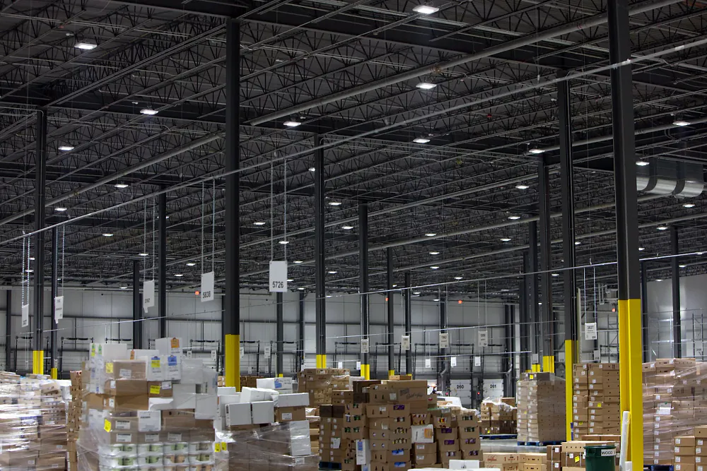 LED high bay lights installed above warehouse racking Warehouse interior with LED high bay lights installed above storage racking