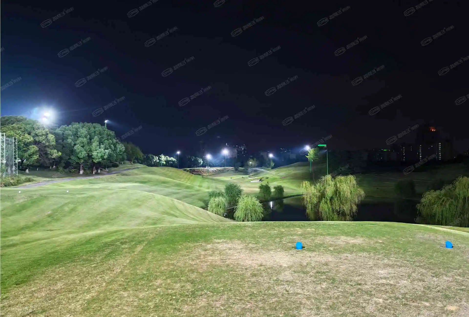 Suzhou golf course: terrain and water beside the lit fairway
